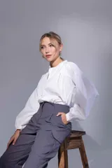 Camisa blanca de poplin 100% algodón, con cuello mao y recortes en delantero pespunteados con frunces. Las mangas largas tienen detalle de frunce tanto en la copa como en sus puños. En la espalda un canesú con detalle de pespunte y en el centro frunces.