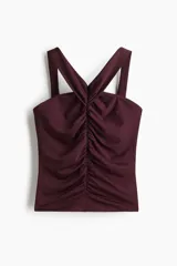 Top de punto elástico color bordó, con breteles anchos que se unen en la espalda. Diseño ceñido con frunces en la parte delantera que crean un leve efecto drapeado.