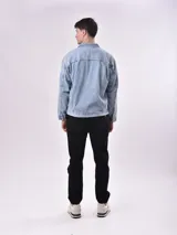 Campera de jean celeste con cuello clásico, cierre frontal con botones metálicos, bolsillos con solapa en el pecho y bolsillos laterales.