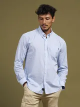Camisa celeste con microestampado, de corte regular fit, con cuello abotonado, manga larga y bolsillo en el pecho.