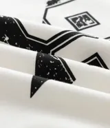 Remera de algodón color blanco con cuello y bordes de mangas en color negro. Presenta una estampa frontal central con el número 98 dentro de una estrella con efecto desgastado.