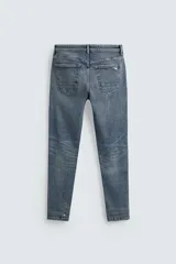 Jeans skinny fit de corte ajustado y tiro medio en color negro con efecto lavado y detalles desgastados. Confeccionados en tejido elástico con mezcla de algodón, presentan diseño clásico de cinco bolsillos y cierre frontal con cremallera y botón.