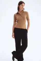 Top de punto color camel, ajustado al cuerpo, con cuello camisero, tapeta de botones y costuras decorativas frontales.