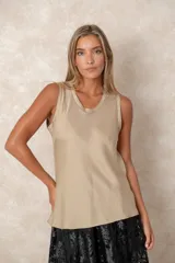 Musculosa de cuello redondo con acabado satinado y caída fluida.