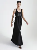 Vestido largo de fiesta negro, con top de lentejuelas y falda larga de corte recto.