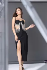 Vestido midi negro con escote corazón, breteles finos y falda ajustada con tajo lateral. Presenta apliques de flecos de strass en el busto y recortes laterales.
