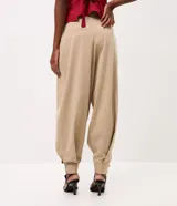 Pantalón de sastre tipo balloon color beige, con pinzas delanteras que aportan volumen, piernas amplias y bajo ajustado. Cuenta con cintura estructurada y pasacintos.