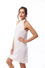 Vestido corto color rosa pálido, con cuello halter y corte recto.