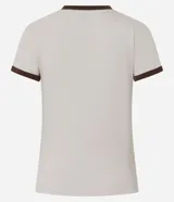 Blusa estilo baby tee color marrón, con cuello redondo y bordes de las mangas en color crema contrastante. Presenta un corte ajustado y manga corta.