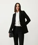 Blazer alargado negro con cuello solapa, bolsillos incorporados y cierre frontal con dos botones.