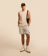 Musculosa básica de hombre, color blanco, con cuello redondo, sin mangas y pequeña etiqueta aplicada en el bajo.