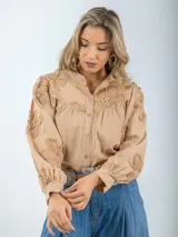 Camisa blanca de broderie con estilo boho y romántico, manga larga levemente abullonada.