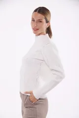 Suéter tejido color blanco con cuello alto y diseño de trenzas.