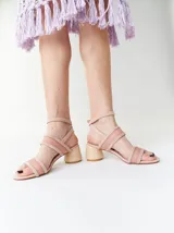 Sandalias de tacón bajo y redondo, con diseño de tiras finas en gamuza y paneles laterales de material translúcido. Cuentan con cierre de pulsera ajustable al tobillo.