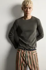 Camiseta de manga larga con cuello redondo, confeccionada en tejido con estructura de canalé y corte relajado.