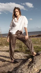 Pantalón de satén con estampado animal print, corte holgado y cintura ajustable con lazo.
