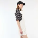 Enterito corto oversize de color blanco, con diseño de peto, tirantes ajustables con hebilla metálica y bolsillos frontales.