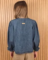 Camisa color beige de lino con mangas abullonadas tres cuartos y cierre frontal mediante múltiples lazos para atar.