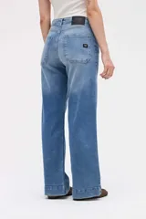 Jean de corte wide leg con tiro medio y cierre frontal con botones a la vista. Presenta un diseño holgado desde la cadera hasta el bajo con pierna ancha.