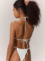 Conjunto de bikini blanco con corpiño triangular con detalle de argolla dorada y bombacha con tiras ajustables y detalle de argolla dorada.
