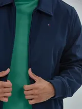 Campera azul marino de poliéster, manga larga con cierre de cremallera, dos bolsillos inferiores y logo de Tommy Hilfiger bordado en el pecho.