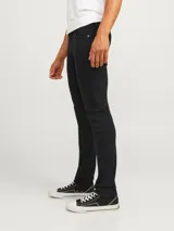 Pantalón jean negro de corte slim fit y tiro medio, con diseño clásico de cinco bolsillos y cierre de cremallera. Confeccionado en tejido de sarga con mezcla de algodón, poliéster, lyocell, viscosa y elastano.