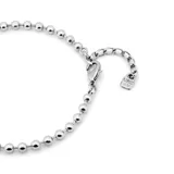 Tobillera elástica plateada con fornitura de bolas.