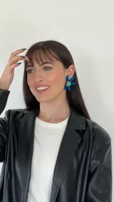 Aros colgantes con forma de flor, con pétalos azules y centro con strass verde.
