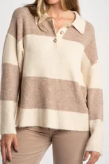 Sweater de punto con cuello polo y cierre frontal de tres botones. Presenta un diseño de corte oversize, mangas largas y textura acanalada.