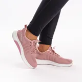 Zapatillas deportivas de mujer color rosa con capellada de malla, cordones y suela blanca.