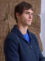 Cardigan de punto color azul marino con textura en relieve, cuello smoking y cierre frontal completo. Posee puños y ruedo acanalados.