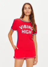 Remera de tejido punto color rojo, manga corta, corte ajustado (slim fit) con cuello redondo ribeteado en blanco y azul marino. Presenta franjas laterales en azul marino con ribete blanco y texto estampado en blanco en el frente que dice "VIBIN HIGH".