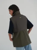 Chaleco verde seco con cuello alto, cierre frontal con cremallera y bolsillos laterales con cierre.