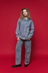 Sobrecamisa de jean de calce relajado color gris, con solapa clásica, bolsillos frontales y cierre de botones metálicos.