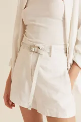 Cinturón blanco con hebilla plateada.