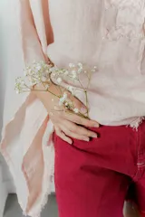 Blusa color rosa pálido de lino con mangas amplias y detalle de costuras en el frente.