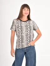 Remera de manga corta con cuello redondo, confeccionada con un estampado animal print de leopardo en tonos negros y beige.