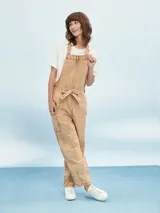 Mono color beige con efecto lavado, corte holgado, breteles regulables y lazo en la cintura.
