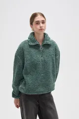 Buzo de textura afelpada con diseño de rayas horizontales finas en tonos marrones. Presenta cuello alto con cierre frontal parcial y mangas largas holgadas.