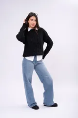 Sweater de punto con diseño de ochos, color marrón, cuello redondo y mangas largas con puños acanalados.