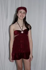Vestido corto azul metalizado con diseño cut-out, argolla central en el busto, tirantes halter y falda con volado en el ruedo.