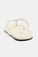 Sandalias planas tipo ojota de color beige, con tira delantera acolchada con separación para el dedo y suela fina.