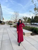 Vestido largo color borgoña, de corte ajustado, con cuello alto y mangas largas.