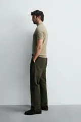 Polo de punto negro, manga corta, con cuello solapa y cierre frontal de tres botones. Presenta un calce regular y acabados en rib en mangas y ruedo.