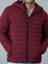 Campera acolchada Calvin Klein color bordó con capucha y cierre frontal con cremallera. Tiene bolsillos laterales con cremallera y logo de la marca en el pecho y en la manga.