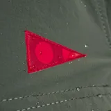 Bermuda verde militar de corte recto, con cintura elástica ajustable con cordón negro y logo triangular rojo en la pierna izquierda.