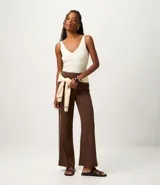 Blusa sin mangas de punto acanalado color crema, con escote en V y espalda descubierta. Confeccionada en una mezcla de viscosa y poliamida, presenta un ajuste al cuerpo y textura vertical en relieve.