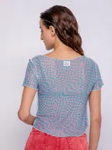 Top de mangas cortas con estampado geométrico en tonos verde y amarillo, con transparencias y costuras a la vista.