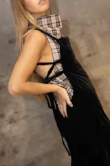 Enterito de terciopelo negro con diseño de pierna ancha y bolsillos laterales tipo cargo. Presenta espalda descubierta con tiras ajustables y bordado decorativo en la parte trasera.