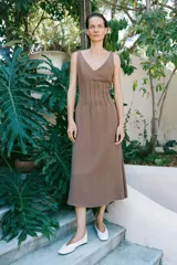 Vestido midi marrón de punto con escote en V y tirantes finos, con detalle de costuras verticales en el talle y falda acampanada.